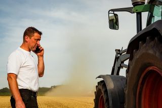 Foto: Landwirt neben Traktor
